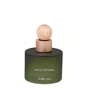 A 120ml cylindrical car perfume bottle with a dark olive green body, a metallic rose gold collar, and a round wooden stopper, on a plain white background.