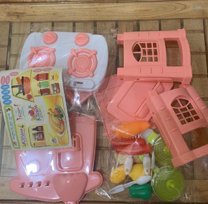 Pink pretend kitchen toys with pots pans and utensils
