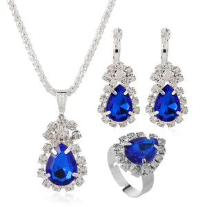 Jewelry set with blue teardrop stones on a white background