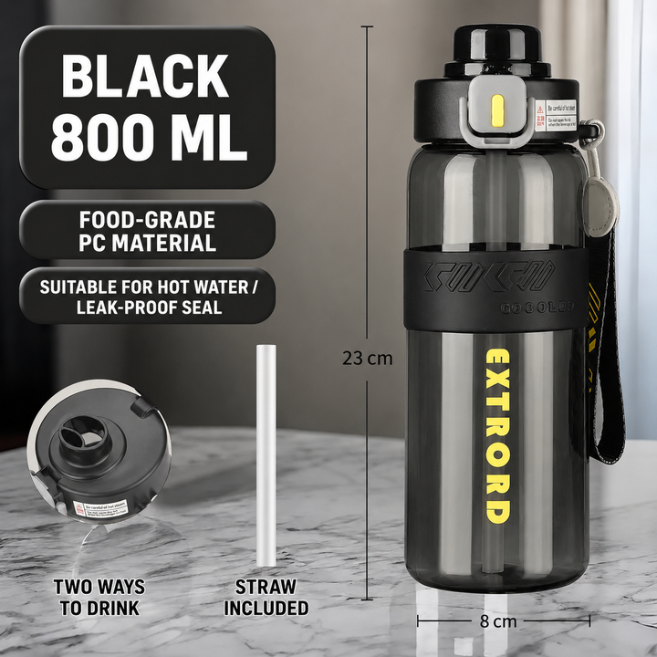 A 800 ml black water bottle with a carrying strap, shown on a marble countertop with overlaid dimension lines, text about food-grade PC material, and a separate straw shown beside it.